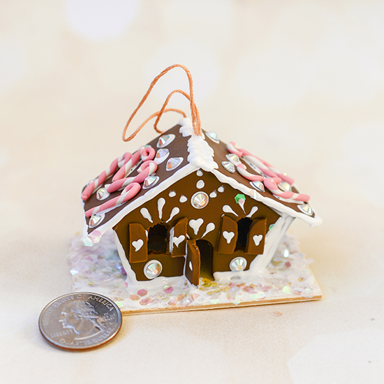 Make a miniature gingerbread house ornament using polymer clay and puff paint.