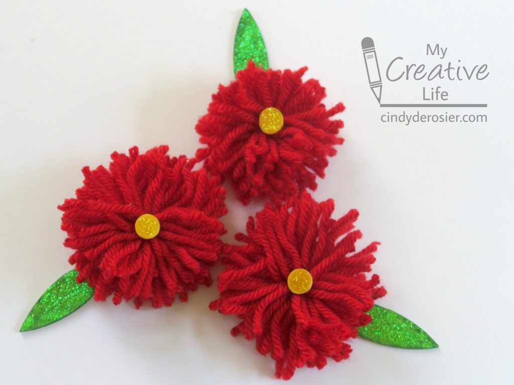 Top gifts with these cute yarn pom pom flowers.